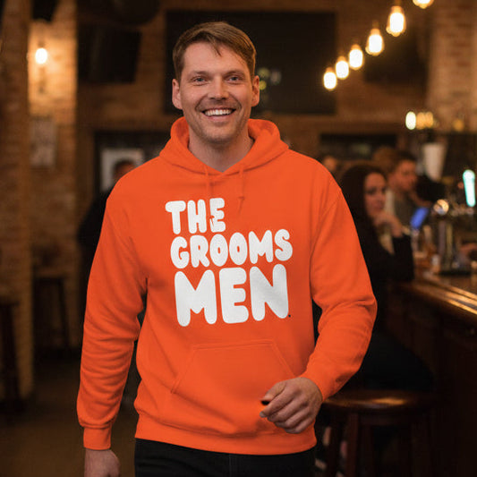 Man wearing The Groomsmen Unisex Hoodie in Orange