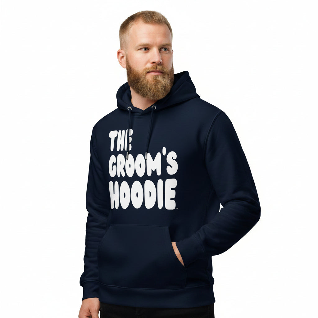 Man wearing the APWT Gift Shop's The Groom's Hoodie Premium Unisex Hoodie from the APWT Wedding Shop in navy Blue