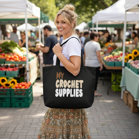Woman standing in a farmer's market carrying the APWT Gift Shop's My Crochet Supplies Jumbo Black Tote Bag from the Day in the Life Collection