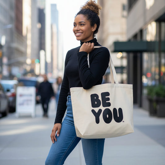 Woman standing on a city sidewalk wearing The APWT Gift Shop's Be You in Black Jumbo Tote Bag from the Be You Collection