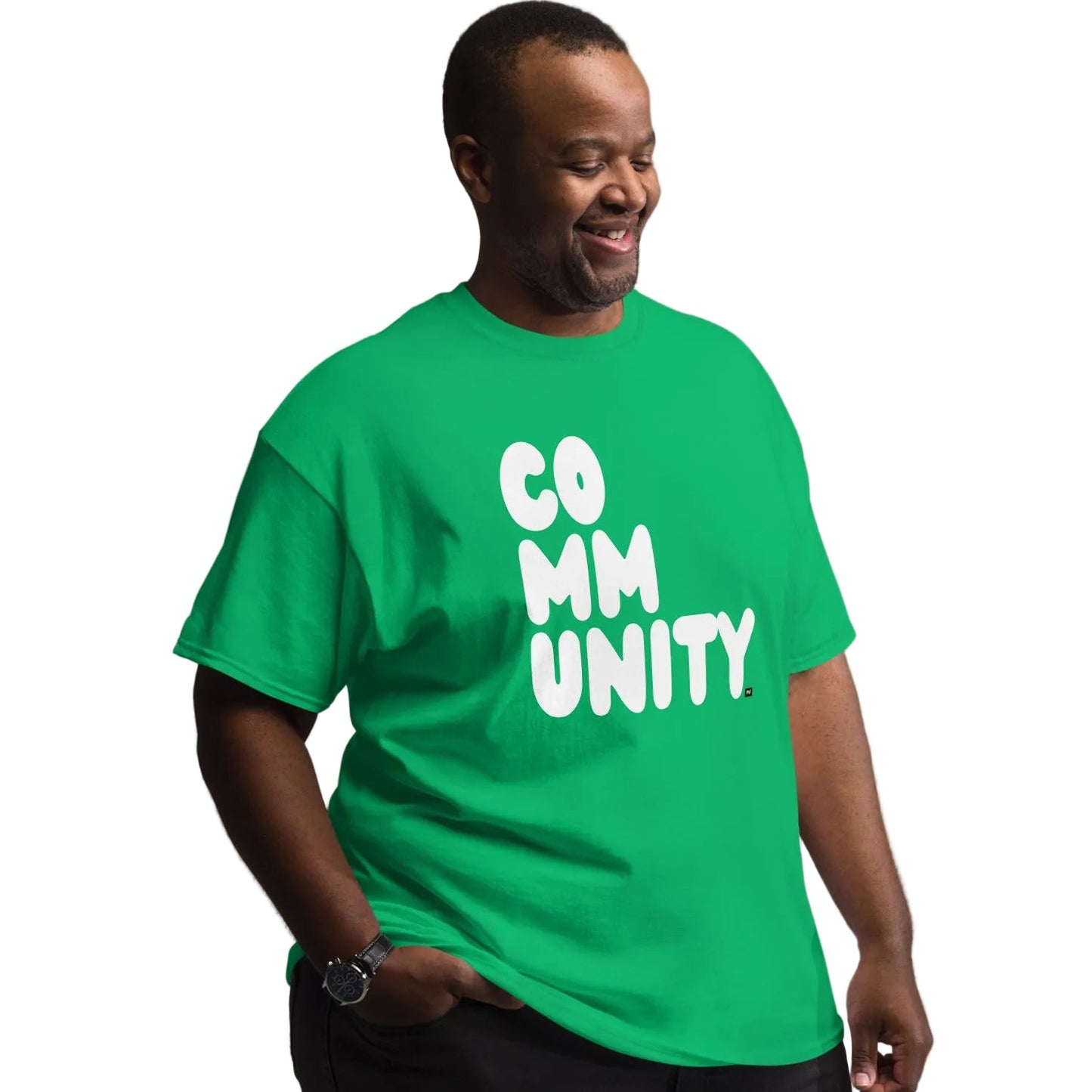 man wearing A Community in Green Grass Unisex T-Shirt from the APWT Gift Shop inclusive sizing