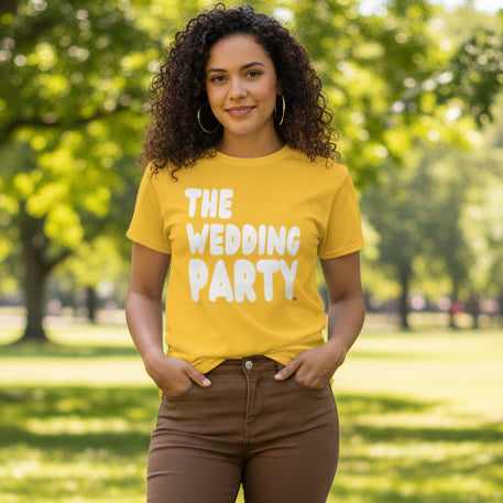 Woman standing in the park wearing the APWT Gift Shop's The Wedding Party Unisex T-Shirt from the APWT Wedding Shop in Yellow