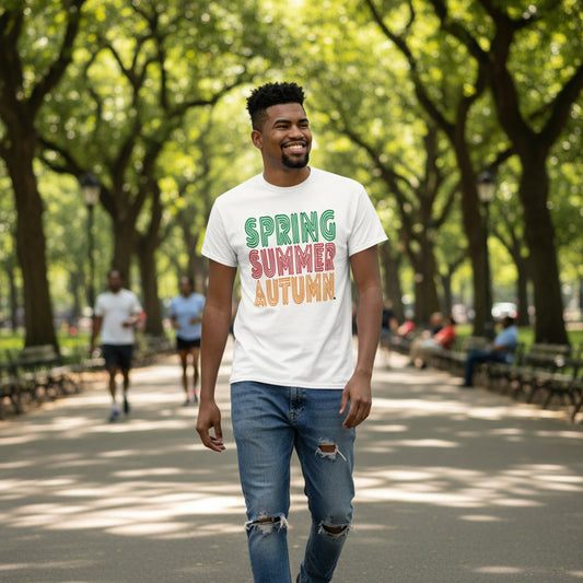 Man wearing a white t-shirt with 'Spring Summer Autumn' text in a park.