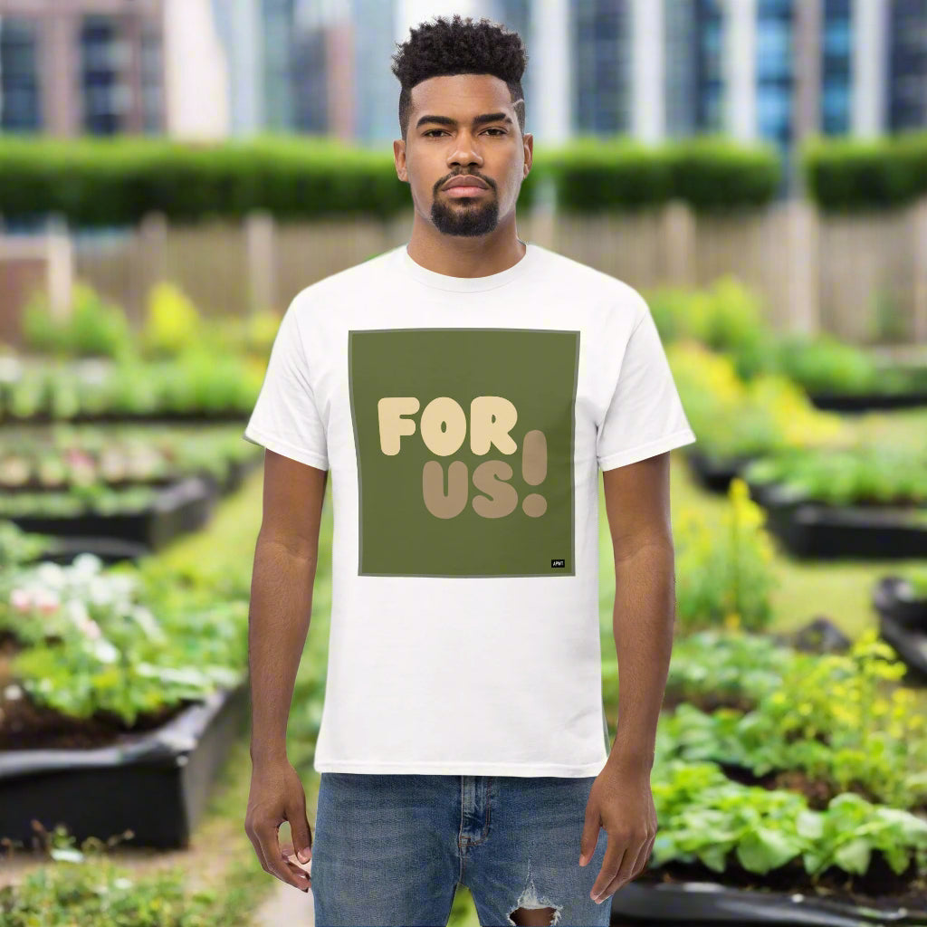 Man wearing the For Us in Green Unisex T-Shirt in White standing in a community garden - The APWT Gift Shop