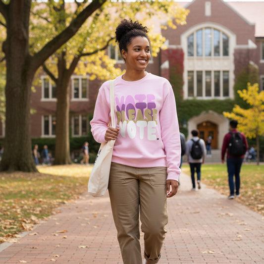 Woman walking through a college campus wearing the APWT Gift Shop's Please Vote in Primaries Pink Unisex Crew Neck Sweatshirt from the APWT Vote Shop