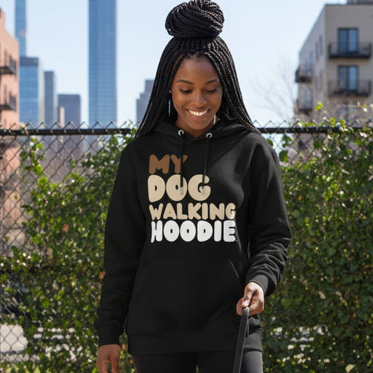 Woman standing on a city street wearing the APWT Gift Shop's My Dog Walking Hoodie Premium Unisex Hoodie from the Day in the Life Collection in Black