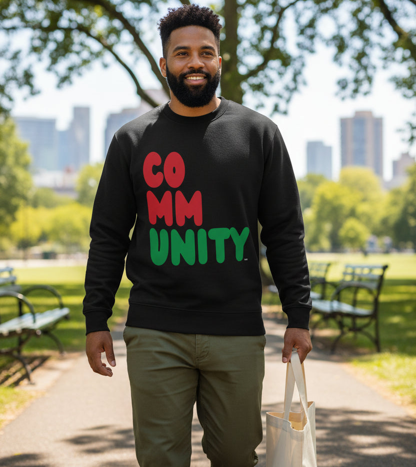 man walking through a city park wearing the APWT Gift Shop's Black Community Premium Unisex Crew Neck Sweatshirt from the Community Collection and the Premium Basics Collection