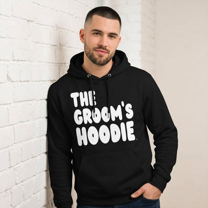 Man wearing the Groom's Hoodie Premium Unisex Hoodie From the APWT Wedding Shop in Black