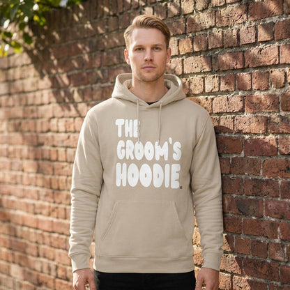 Man wearing the Groom's Hoodie Premium Unisex Hoodie From the APWT Wedding Shop in Beige