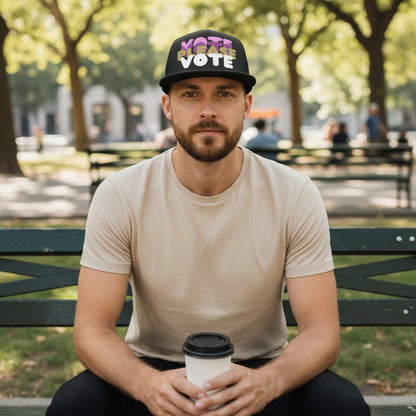 man sitting in the park on a bench wearing the APWT Gift Shop's Please Vote in Pink Trucker Hat from the APWT Vote Shop