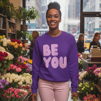 Woman standing in a flower shop wearing The APWT Gift Shop's Be You in Purple and Pink Unisex Crew Neck Sweatshirt from the Be You Collection 
