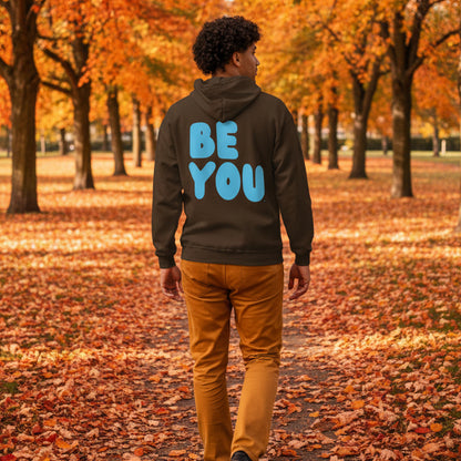 Man walking through the park on an autumn day wearing the APWT Gift Shop's Be You in Brown and Blue Unisex Zip-Up Hoodie from the Be You Collection