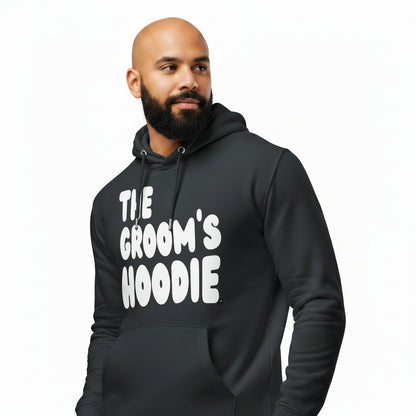 Man wearing the APWT Gift Shop's The Groom's Hoodie Premium Unisex Hoodie from the APWT Wedding Shop in Charcoal Grey