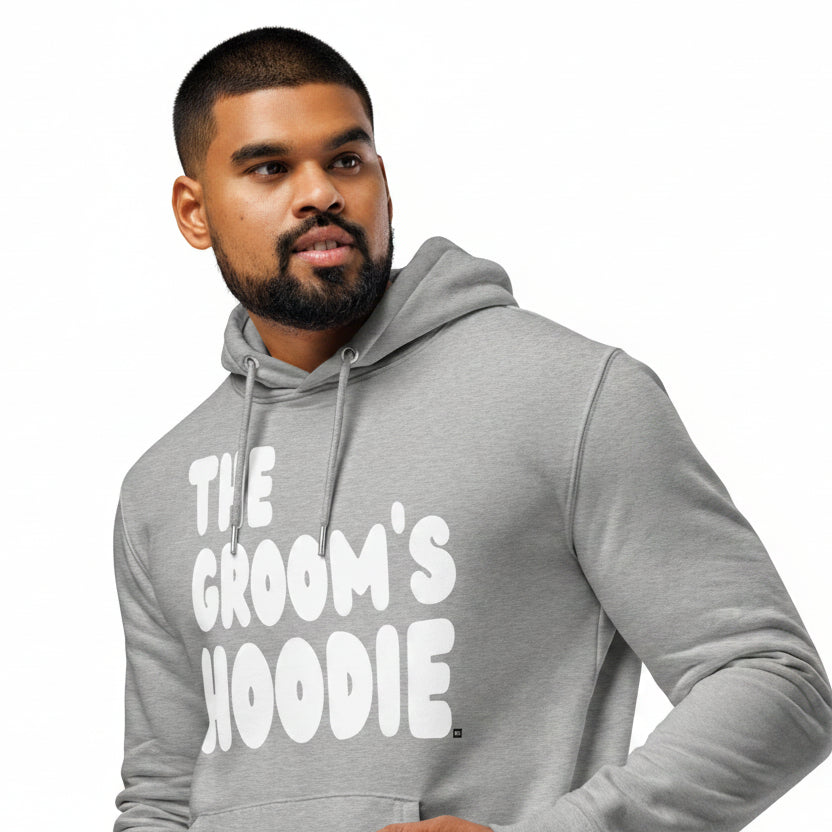 Man wearing the APWT Gift Shop's The Groom's Hoodie Premium Unisex Hoodie from the APWT Wedding Shop in Grey