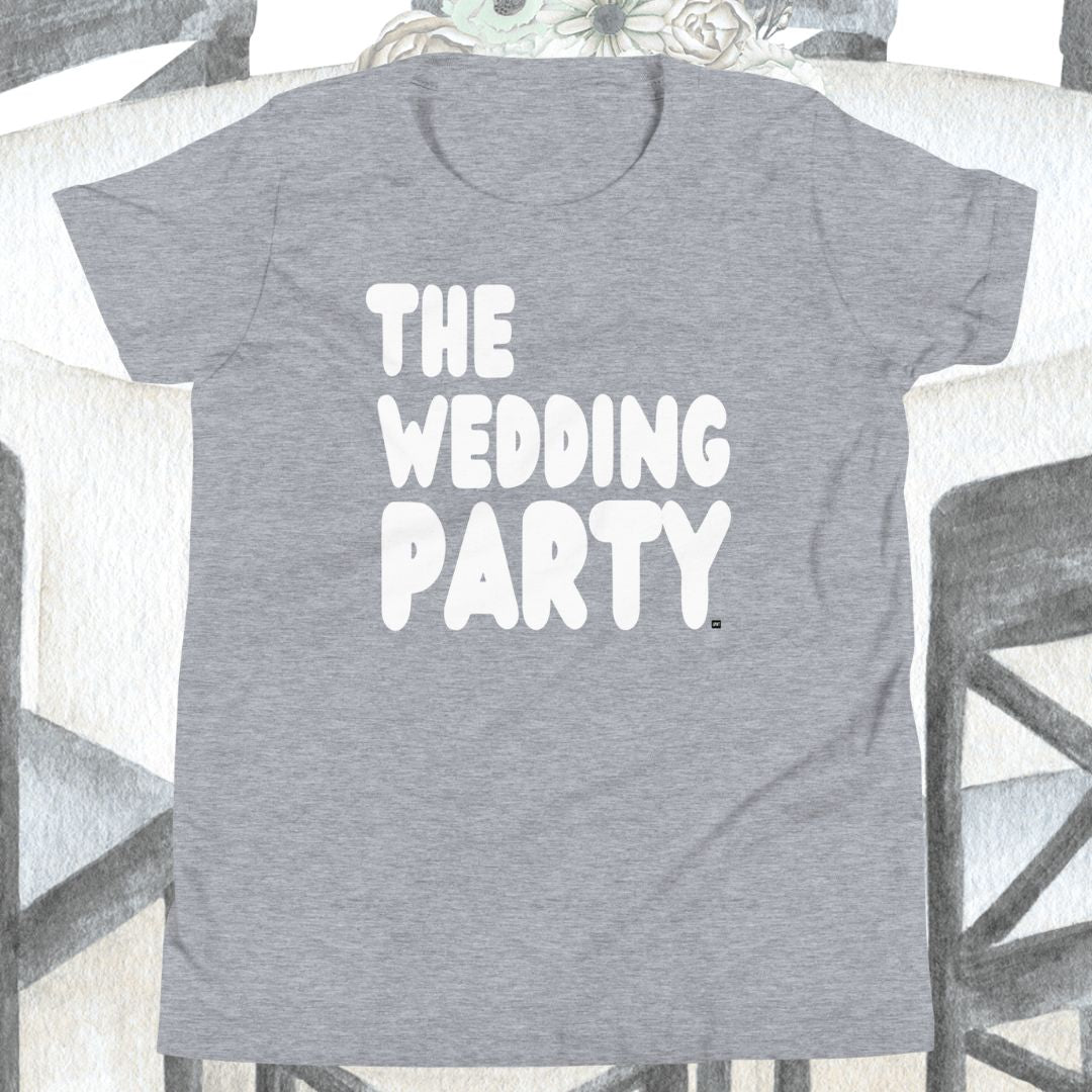 Gray t-shirt with 'THE WEDDING PARTY' text on a chair.