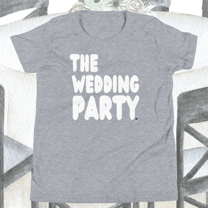 Gray t-shirt with 'THE WEDDING PARTY' text on a chair.