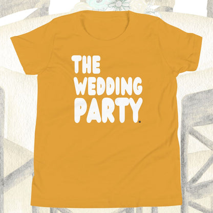 Yellow t-shirt with 'THE WEDDING PARTY' text on a white chair.