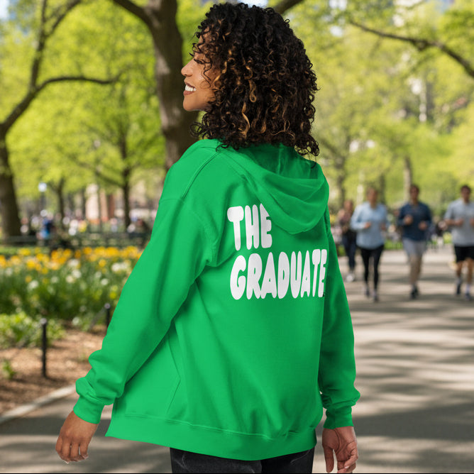 Woman wearing The Graduate Unisex Zip-Up Hoodie from the APWT Gift Shop in Green
