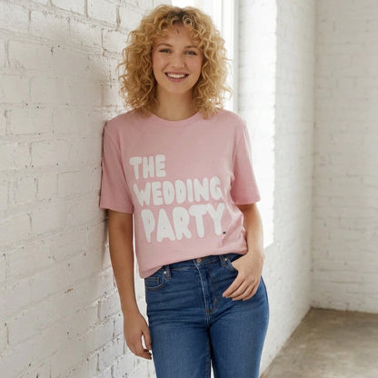 Woman wearing the APWT Gift Shop's the Wedding Party Premium Unisex T-Shirt from the APWT Wedding Shop in Pink