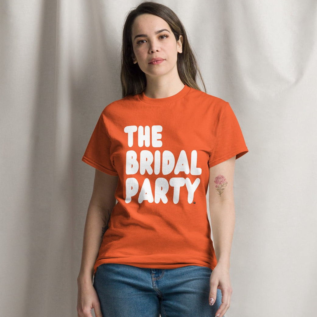 Women wearing The Bridal Party Unisex T-Shirt in from the APWT Gift Shop in Orange