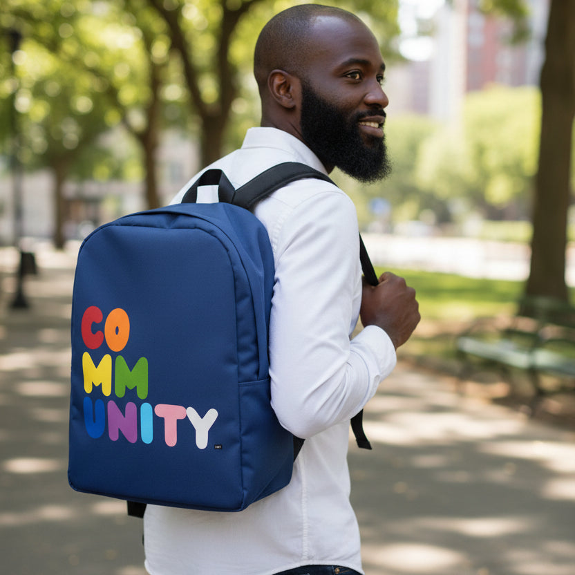 Man walking through park wearing the Rainbow Community Backpack from the Pride in the APWT Gift Shop Collection