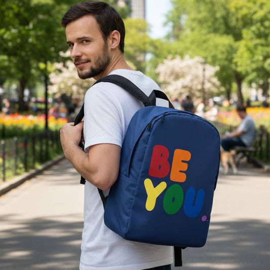 Man wearing the APWT Gift Shop's Rainbow Be You Backpack from the Pride in the APWT Gift Shop Collection