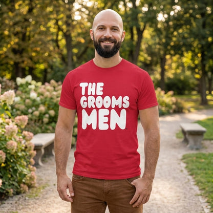 Man standing in a park wearing the APWT Gift Shop's the Groomsmen Unisex T-Shirt  from the APWT Wedding Shop and Day in the Life Collection in Red