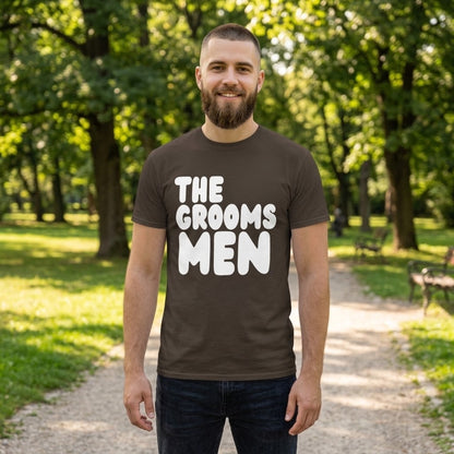 Man standing in a park wearing the APWT Gift Shop's the Groomsmen Unisex T-Shirt  from the APWT Wedding Shop and Day in the Life Collection in Brown