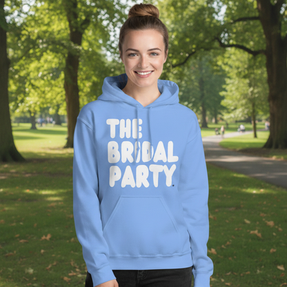Woman standing in a park wearing the APWT Gift Shop's the Bridal Party Unisex Hoodie from the APWT Wedding Shop in light blue