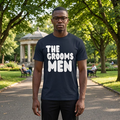 Man standing in a park wearing the APWT Gift Shop's the Groomsmen Unisex T-Shirt  from the APWT Wedding Shop and Day in the Life Collection in Navy Blue