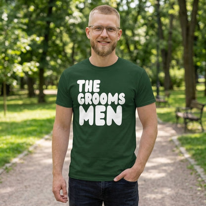 Man standing in a park wearing the APWT Gift Shop's the Groomsmen Unisex T-Shirt  from the APWT Wedding Shop and Day in the Life Collection in Forest Green