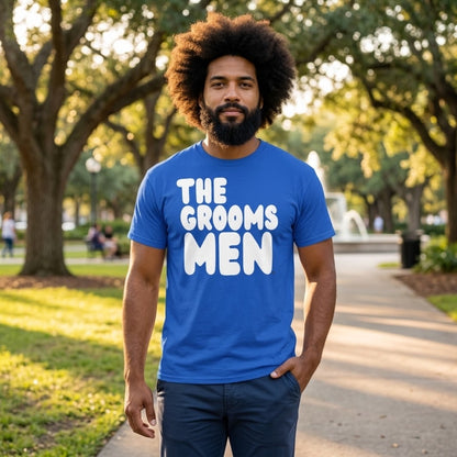 Man standing in a park wearing the APWT Gift Shop's the Groomsmen Unisex T-Shirt  from the APWT Wedding Shop and Day in the Life Collection in Royal Blue