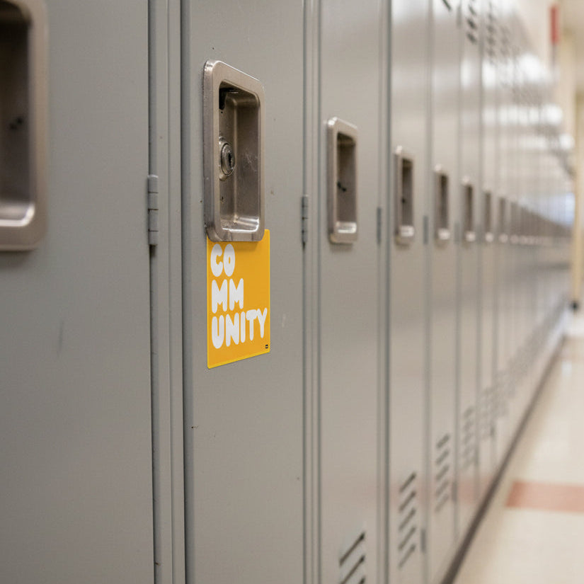 A Community in Sunflower Yellow Vinyl Sticker stuck to a school locker