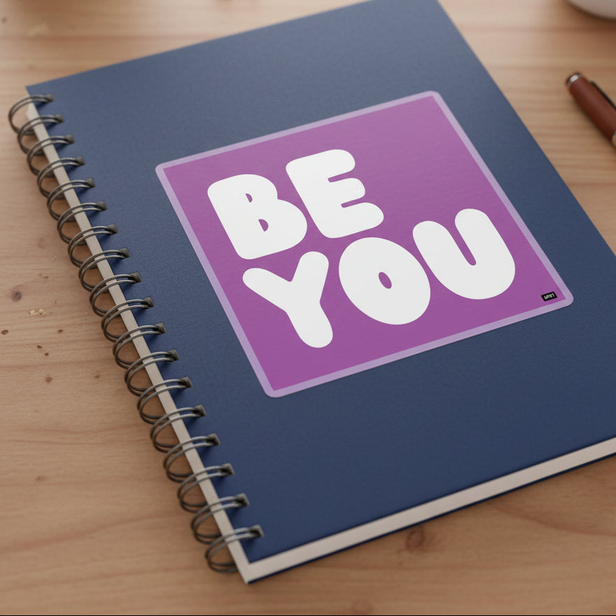 The APWT Gift Shop's Be You in Purple Sticker from the Be You Collection stuck to a notebook