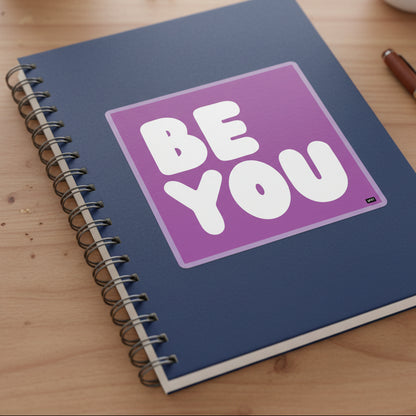 The APWT Gift Shop's Be You in Purple Sticker from the Be You Collection stuck to a notebook