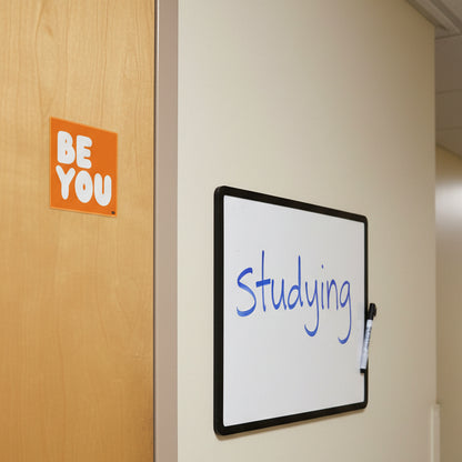 The APWT Gift Shop's Be You in Orange Vinyl Sticker stuck to the outside of a door