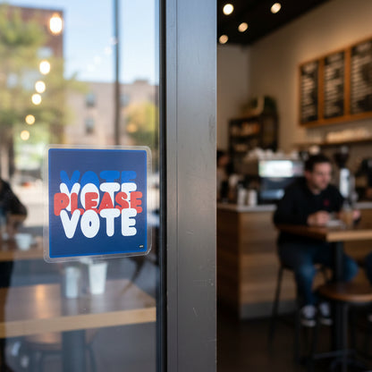 The APWT Gift Shop's Please Vote Vinyl Sticker from the APWT Vote Shop stuck to the outside of a cafe window