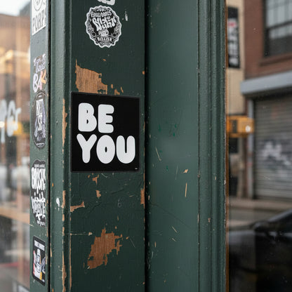 The APWT Gift Shop's Be You in Black and White Vinyl Sticker from the Be You Collection stuck to the outside of a door