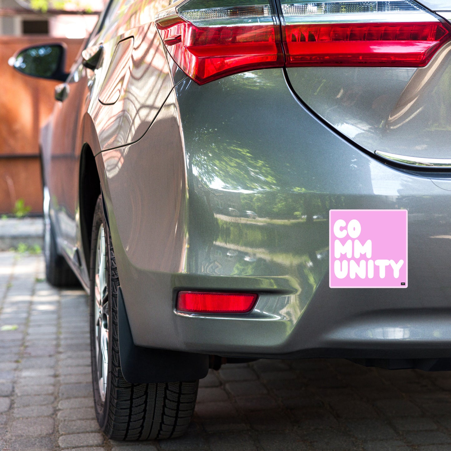 A Community in Pink Vinyl Sticker on a car bumper - The APWT Gift Shop