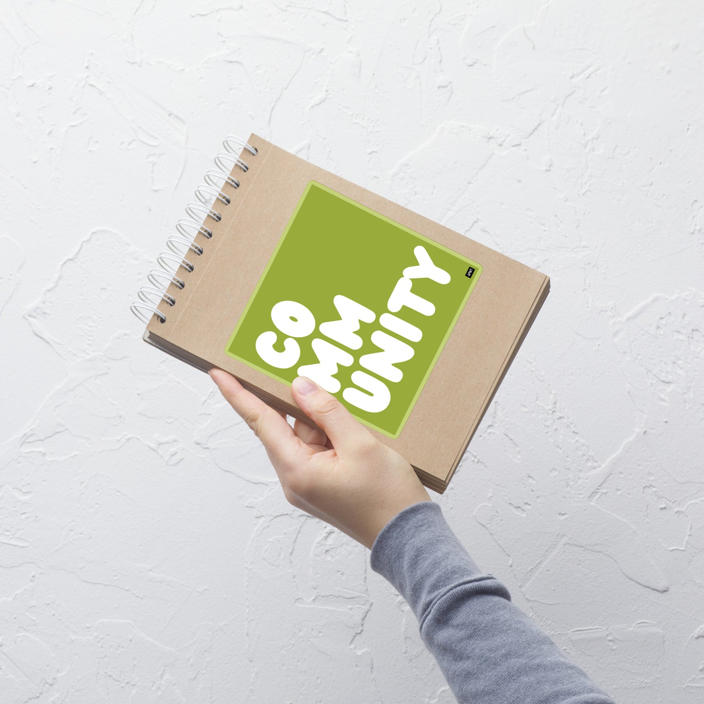 A Community in Lime Green Vinyl Sticker on a notebook- The APWT Gift Shop