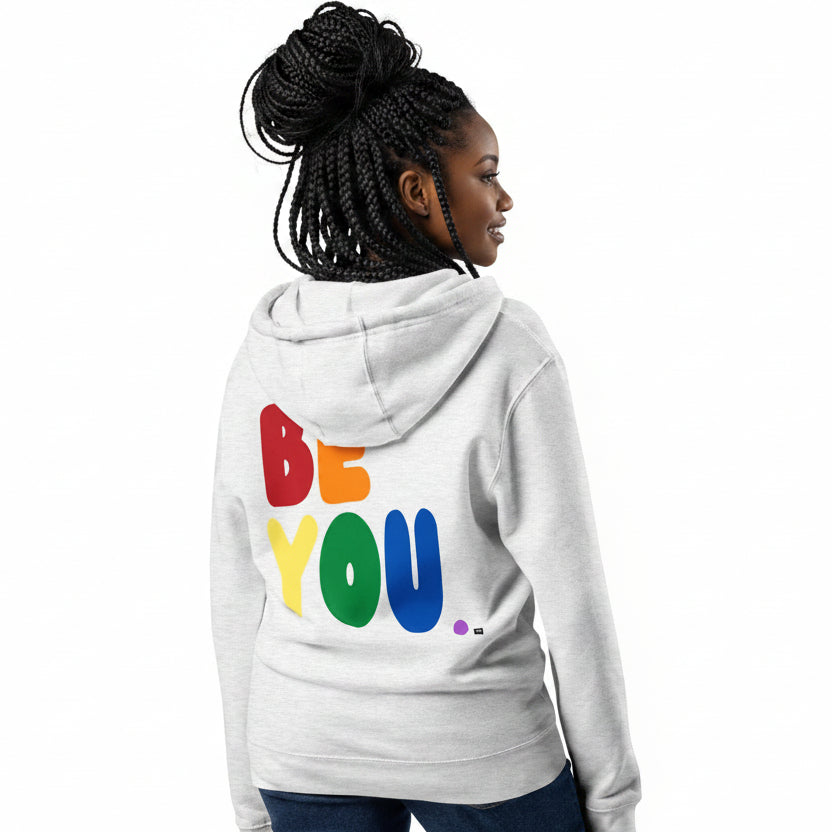 Woman wearing the APWT Gift Shop's Rainbow Be You Premium Unisex Zip-Up Hoodie from the Pride in the APWT Gift Shop Collection in Grey