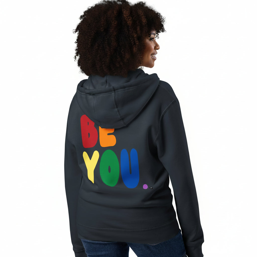 Woman wearing the APWT Gift Shop's Rainbow Be You Premium Unisex Zip-Up Hoodie from the Pride in the APWT Gift Shop Collection in Navy Blue