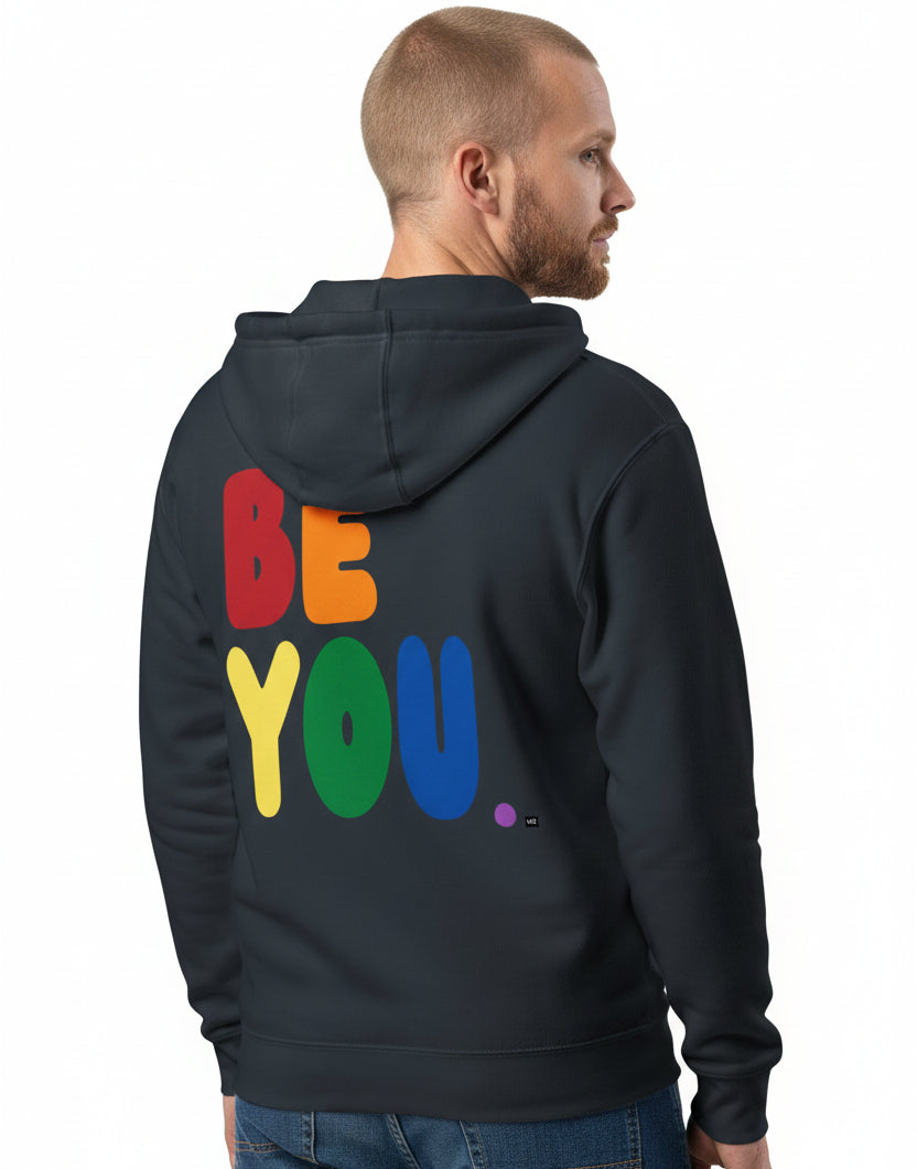 man wearing the APWT Gift Shop's Rainbow Be You Premium Unisex Zip-Up Hoodie from the Pride in the APWT Gift Shop Collection in Navy Blue