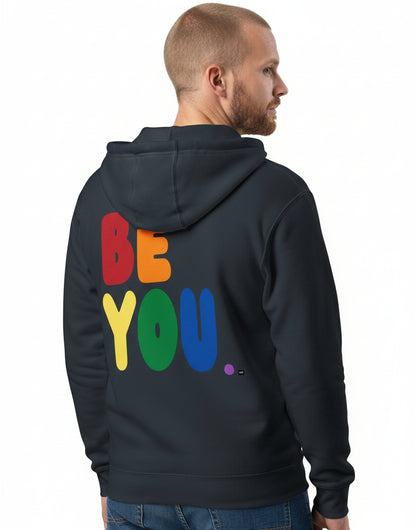 man wearing the APWT Gift Shop's Rainbow Be You Premium Unisex Zip-Up Hoodie from the Pride in the APWT Gift Shop Collection in Navy Blue