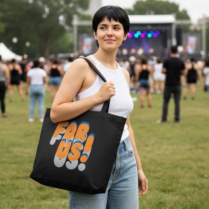 Woman in a city park wearing the APWT Gift Shop's For Us in Blue and Orange Jumbo Tote Bag in Black