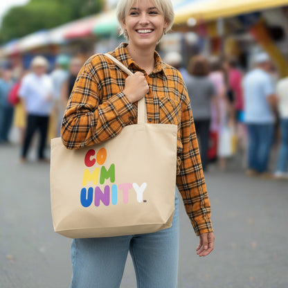 Woman carrying the APWT Gift Shop's Rainbow Community Jumbo Tote Bag from the Pride in the APWT Gift Shop Collection