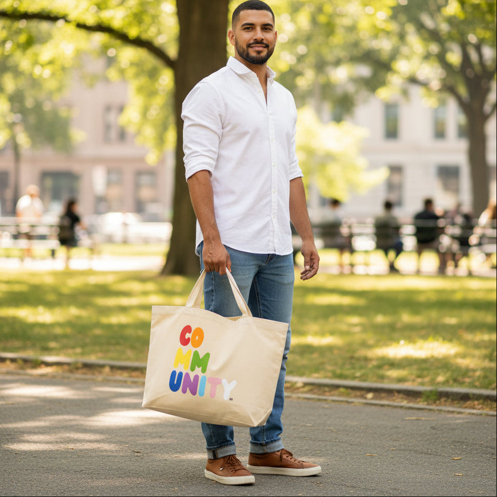 Man carrying the APWT Gift Shop's Rainbow Community Jumbo Tote Bag from the Pride in the APWT Gift Shop Collection