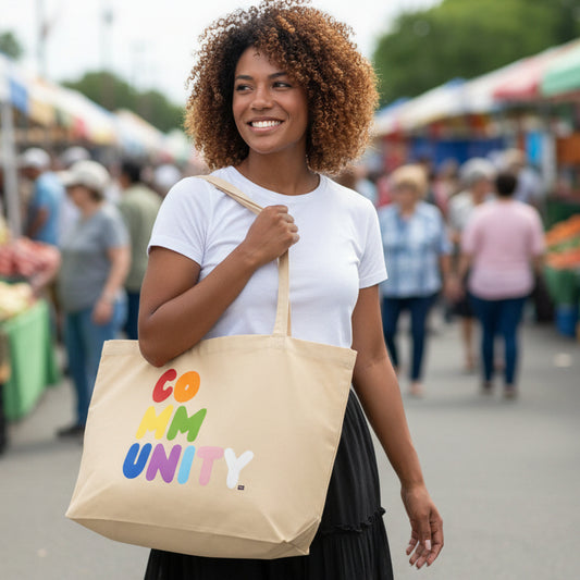 Woman carrying the APWT Gift Shop's Rainbow Community Jumbo Tote Bag from the Pride in the APWT Gift Shop Collection