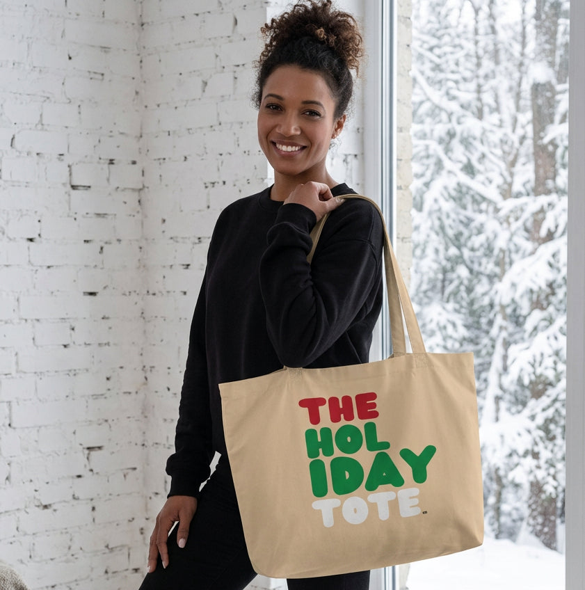 Woman holding the APWT Gift Shop's Holiday Tote Jumbo Tote Bag from the APWT Holiday Shop