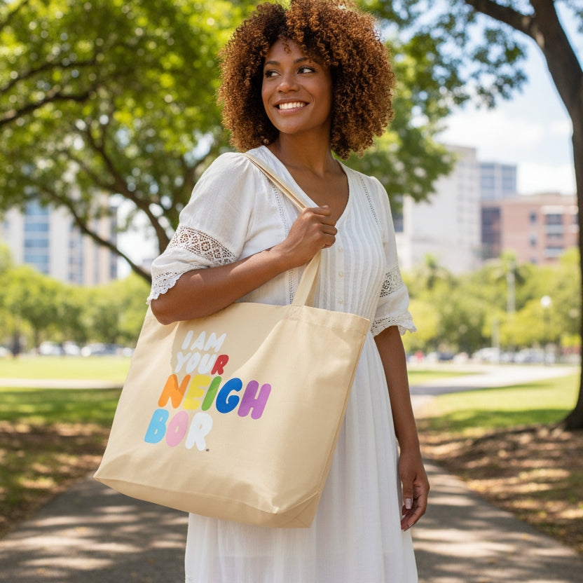 woman carrying the I Am Your Neighbor in Color Jumbo Tote Bag from the Pride in the APWT Gift Shop Collection